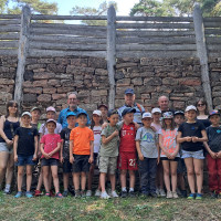 Die Schatzsucher mit den Betreuern vor der Pfostenschlitzmauer